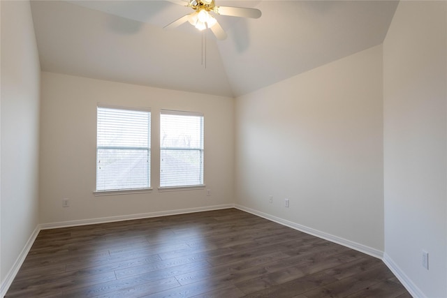 empty room featuring dark wood-type flooring, vaulted ceiling, baseboards, and ceiling fan