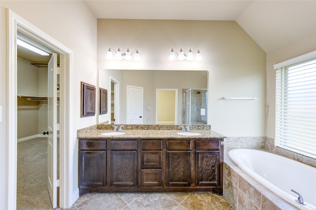 full bathroom featuring a sink, a garden tub, a shower stall, and vaulted ceiling