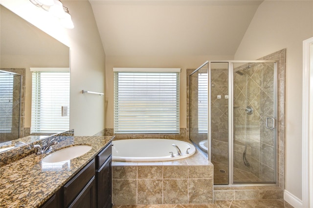 bathroom featuring a bath, a stall shower, and lofted ceiling