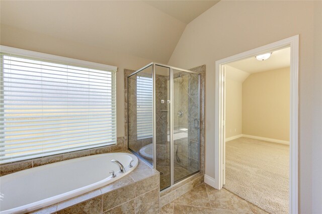 bathroom featuring lofted ceiling, a bath, a stall shower, and tile patterned floors