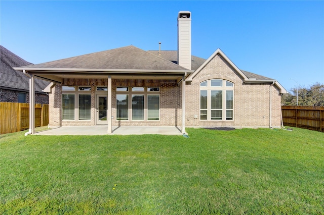 back of house featuring a lawn, a fenced backyard, and a patio area