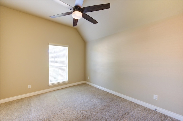 carpeted empty room featuring baseboards, ceiling fan, and vaulted ceiling