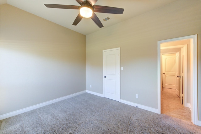 unfurnished bedroom featuring lofted ceiling, light colored carpet, visible vents, and baseboards