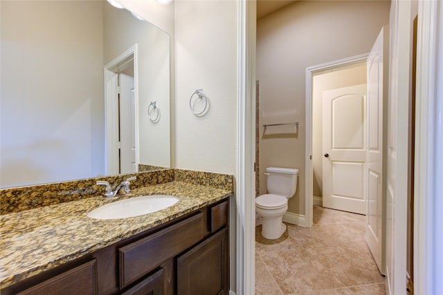 bathroom with toilet, vanity, and tile patterned flooring