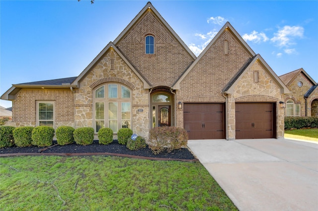 view of front of property featuring brick siding, stone siding, driveway, and a garage