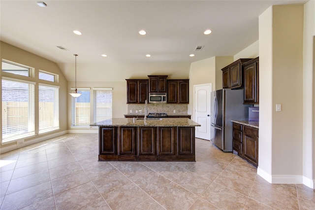 kitchen with light stone counters, visible vents, lofted ceiling, stainless steel appliances, and tasteful backsplash