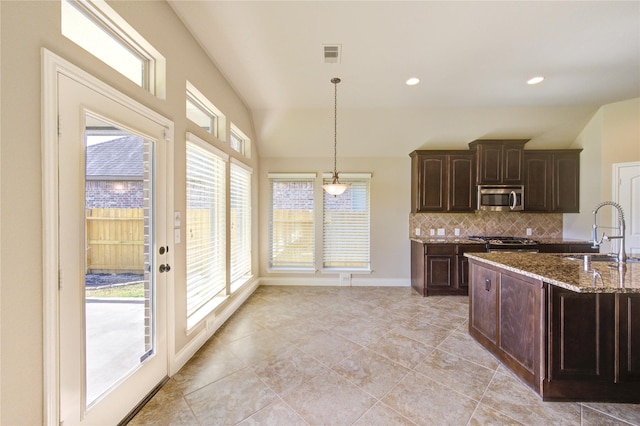 kitchen with visible vents, lofted ceiling, a sink, appliances with stainless steel finishes, and backsplash