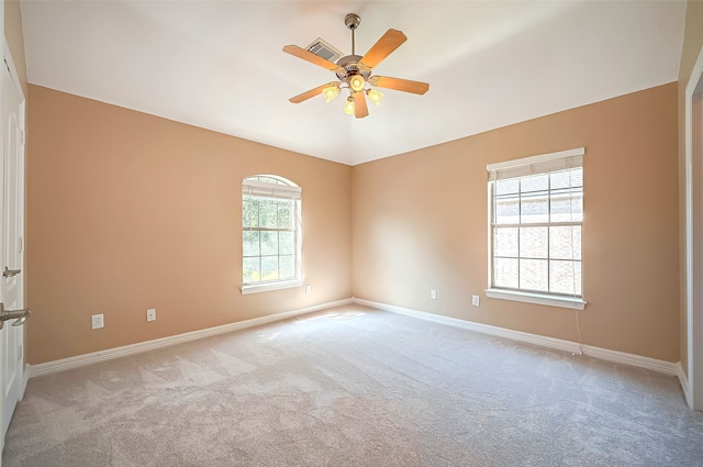 unfurnished room with a ceiling fan, lofted ceiling, light colored carpet, and baseboards