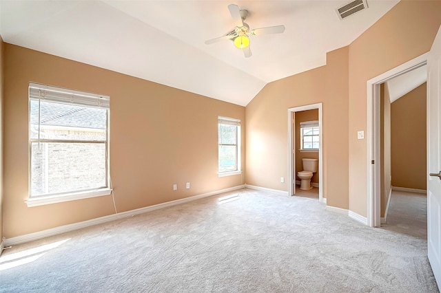 interior space with visible vents, baseboards, lofted ceiling, ceiling fan, and light colored carpet