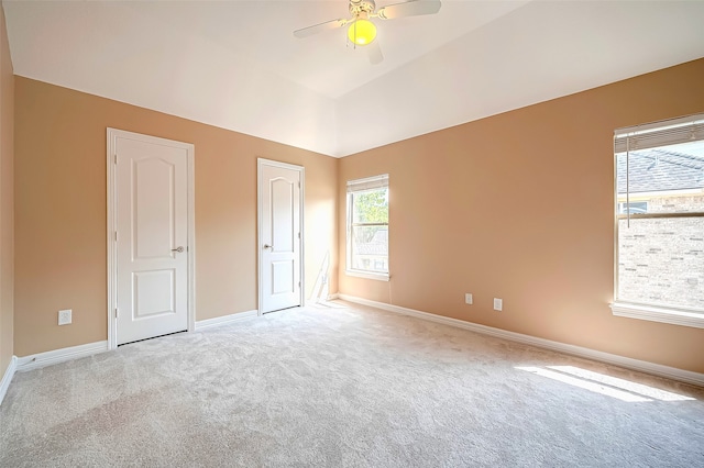 unfurnished bedroom with lofted ceiling, carpet flooring, a ceiling fan, and baseboards