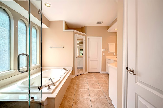 bathroom featuring tile patterned floors, visible vents, a jetted tub, and vanity