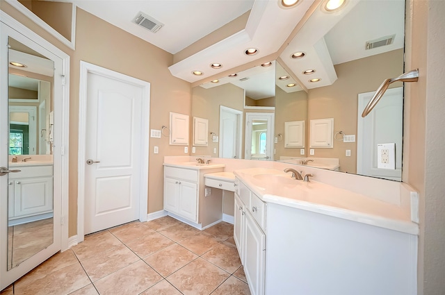 full bath featuring tile patterned floors, visible vents, two vanities, and a sink