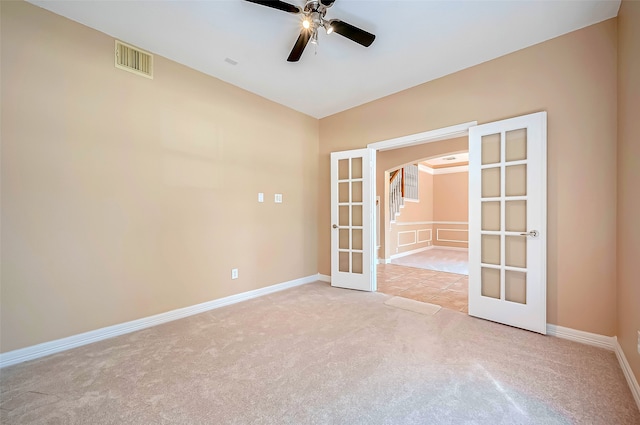 spare room featuring visible vents, arched walkways, ceiling fan, french doors, and carpet flooring