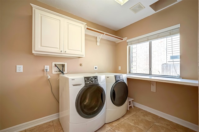 laundry room with baseboards, visible vents, washing machine and clothes dryer, light tile patterned flooring, and cabinet space