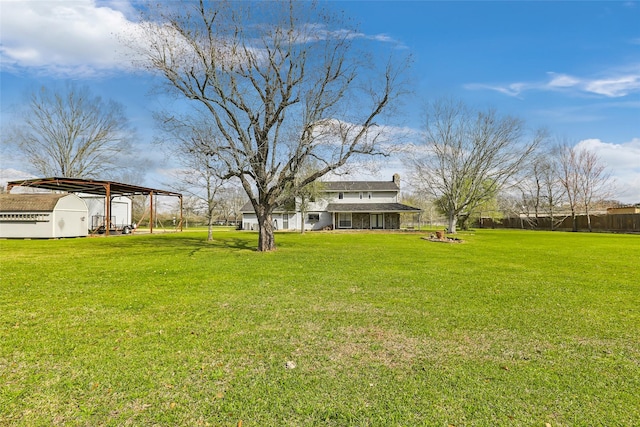 view of yard with a carport and fence