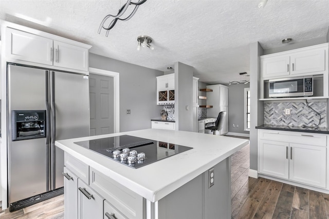 kitchen with white cabinetry, tasteful backsplash, dark wood-style flooring, and appliances with stainless steel finishes