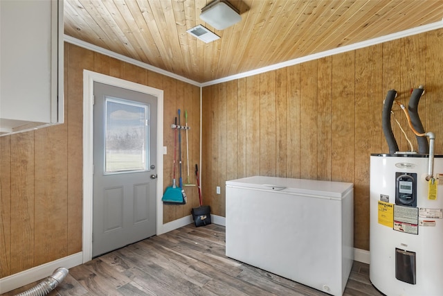 laundry area featuring wooden walls, water heater, laundry area, wooden ceiling, and wood finished floors