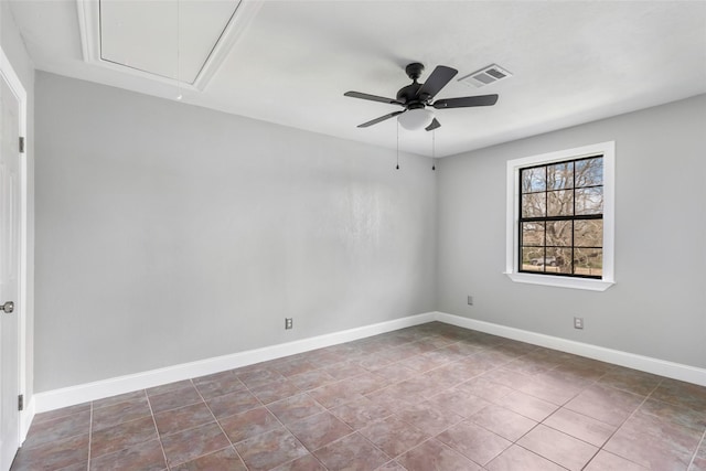 spare room with tile patterned floors, visible vents, baseboards, attic access, and ceiling fan