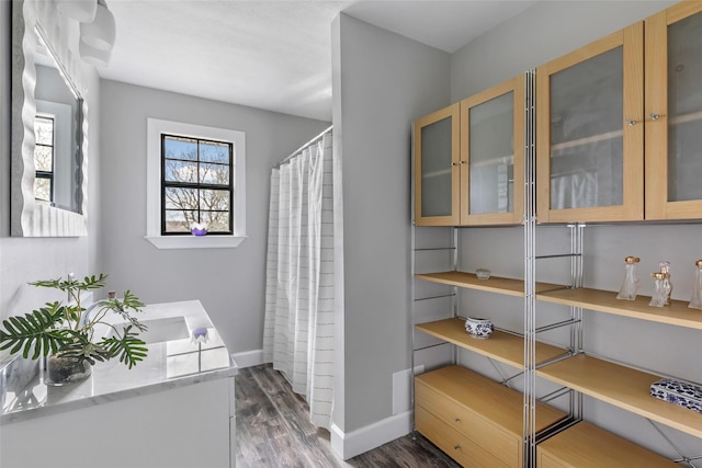 full bathroom with curtained shower, baseboards, wood finished floors, and vanity