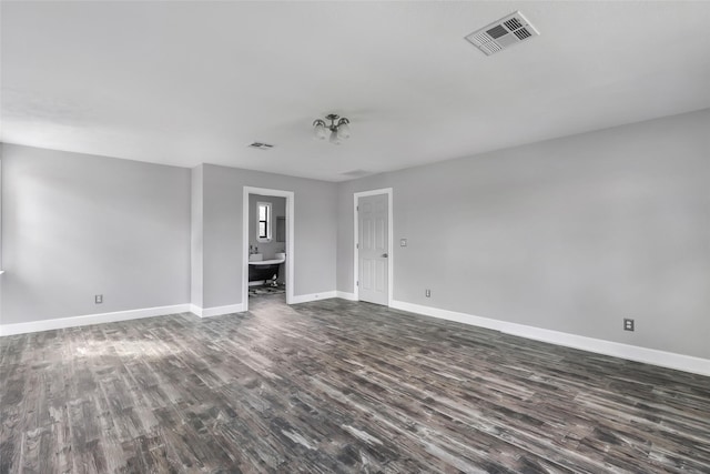 spare room with visible vents, baseboards, and dark wood-style flooring