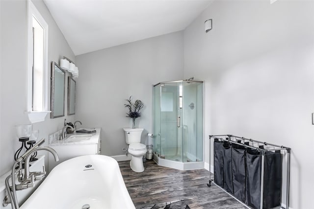 full bathroom with a freestanding tub, toilet, wood finished floors, a shower stall, and lofted ceiling