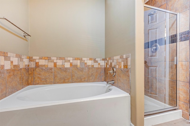 full bathroom featuring a shower stall and a garden tub