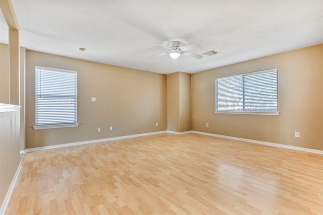 spare room with visible vents, baseboards, light wood-style flooring, and a ceiling fan