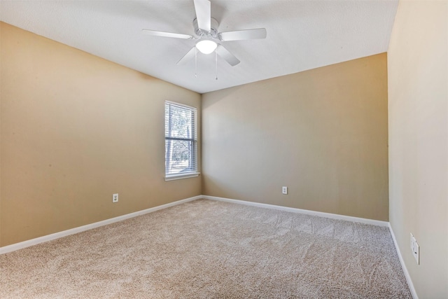 carpeted empty room featuring baseboards and a ceiling fan