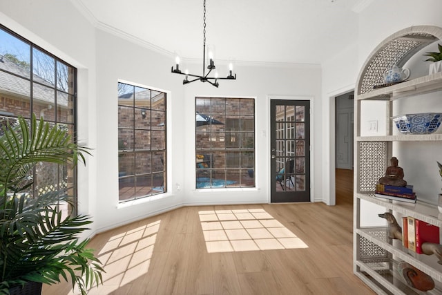 interior space featuring an inviting chandelier, wood finished floors, and ornamental molding