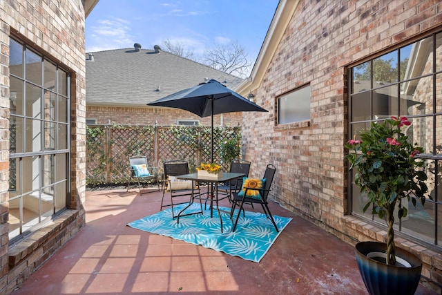 view of patio featuring outdoor dining area and fence