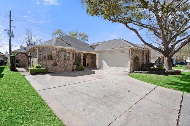 single story home featuring brick siding, an attached garage, concrete driveway, and a front lawn