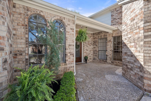 view of exterior entry featuring brick siding