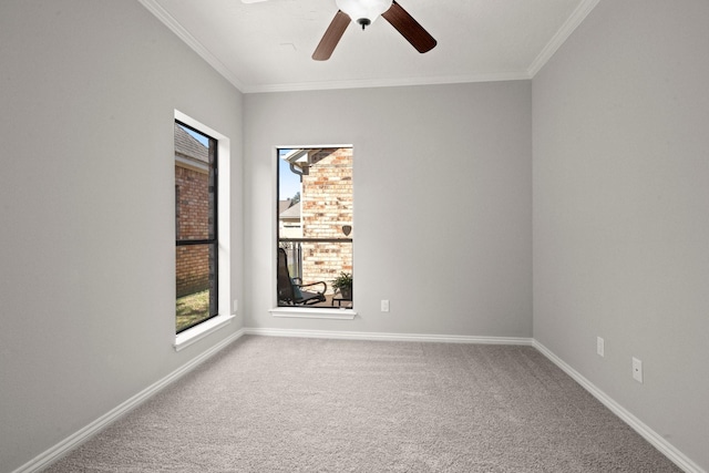 carpeted empty room featuring baseboards, ceiling fan, and crown molding