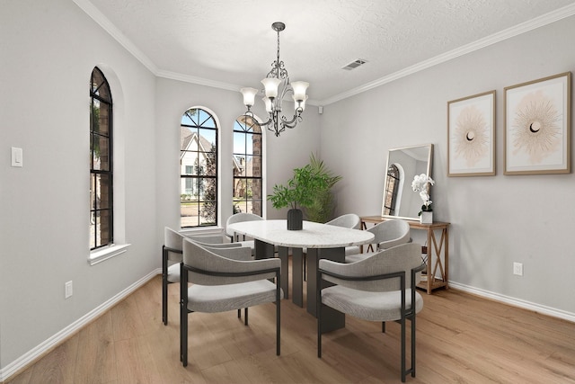 dining area with baseboards, visible vents, crown molding, a notable chandelier, and light wood-type flooring