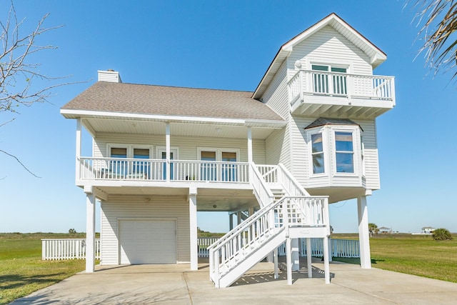 4010 Kiva Rd, Galveston, TX 77554 - raised beach house with an attached garage, concrete driveway, a balcony, a carport, and a chimney