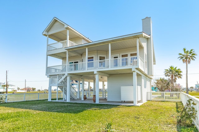 4010 Kiva Rd, Galveston, TX 77554 - back of property with a chimney, a balcony, a patio, and a carport