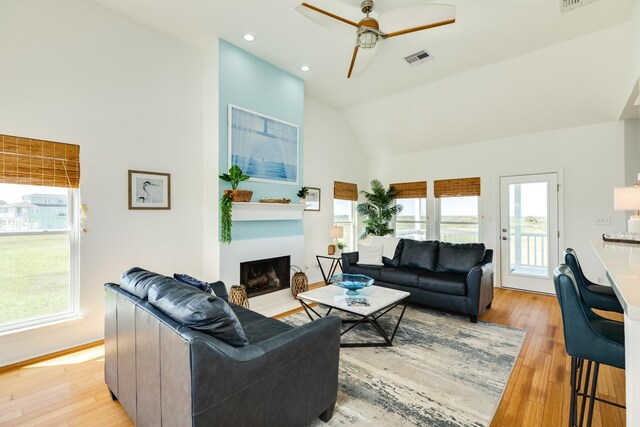 4010 Kiva Rd, Galveston, TX 77554 - living room featuring light wood-style floors, a ceiling fan, a fireplace with flush hearth, high vaulted ceiling, and recessed lighting
