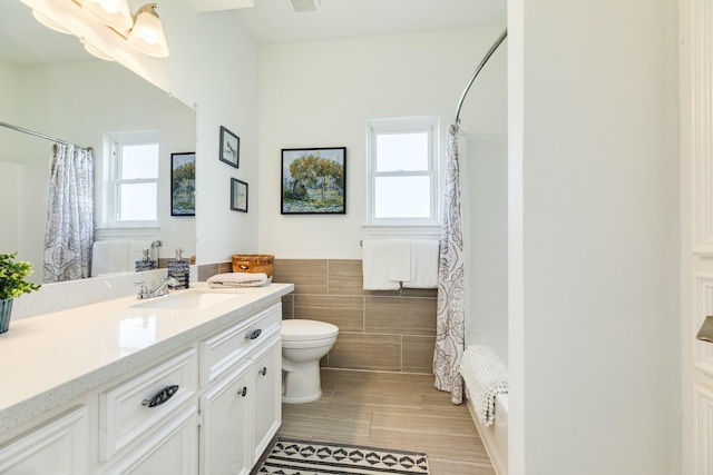 4010 Kiva Rd, Galveston, TX 77554 - full bathroom featuring tile walls, toilet, vanity, and a shower with shower curtain