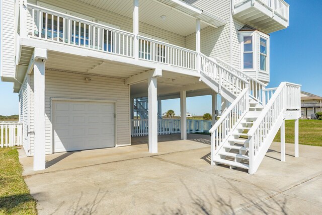 4010 Kiva Rd, Galveston, TX 77554 - view of side of property featuring an attached garage, driveway, stairs, and a carport