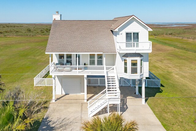 4010 Kiva Rd, Galveston, TX 77554 - coastal inspired home with a porch, concrete driveway, stairs, and a front lawn