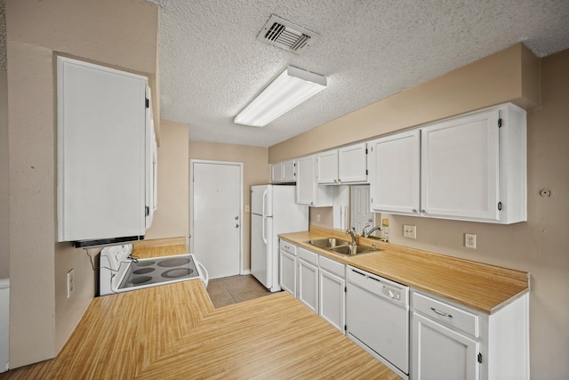 kitchen featuring white appliances, visible vents, a sink, light countertops, and white cabinets