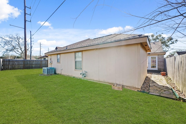 back of property featuring cooling unit, a lawn, roof with shingles, and a fenced backyard