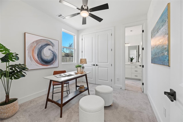 office featuring ceiling fan, baseboards, visible vents, and light carpet