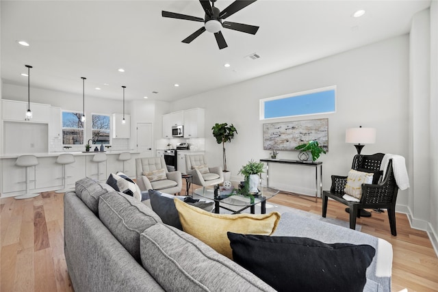 living area featuring light wood-style flooring, recessed lighting, a ceiling fan, and visible vents