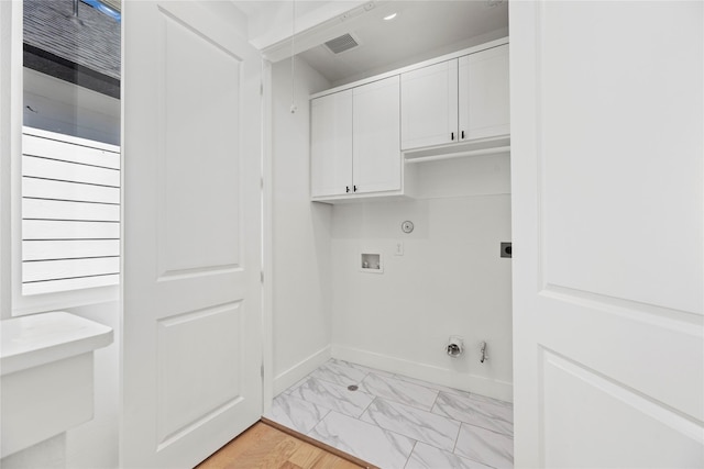 laundry room featuring marble finish floor, hookup for a gas dryer, cabinet space, hookup for an electric dryer, and hookup for a washing machine