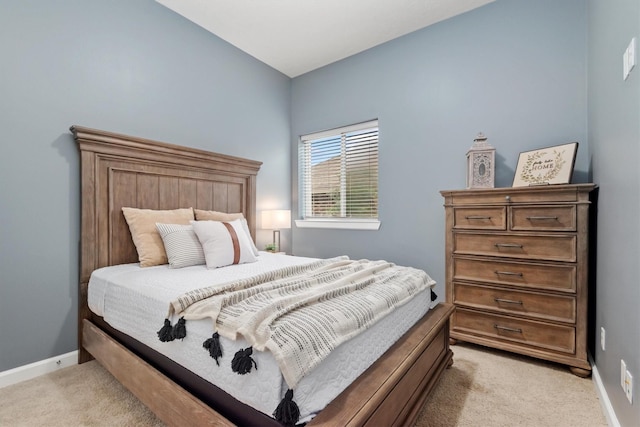 bedroom with light colored carpet and baseboards