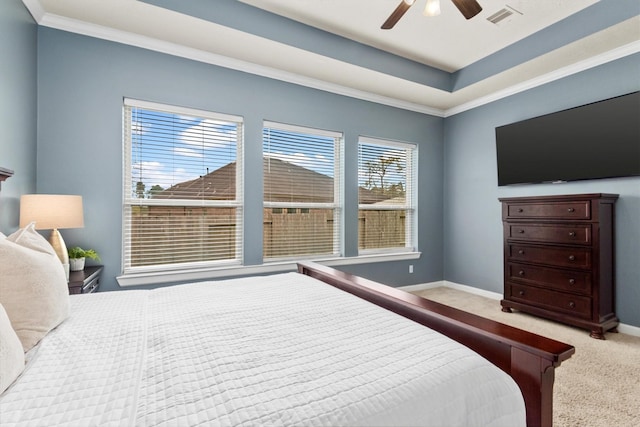 carpeted bedroom featuring visible vents, ceiling fan, baseboards, a tray ceiling, and ornamental molding