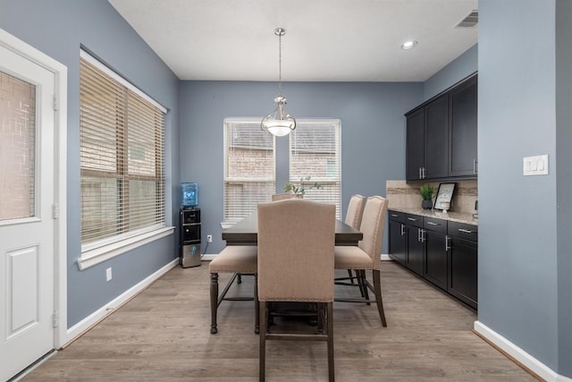 dining space featuring plenty of natural light, light wood-style flooring, and baseboards