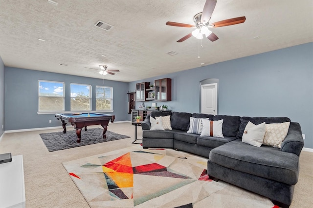 carpeted living area with billiards, arched walkways, visible vents, and ceiling fan