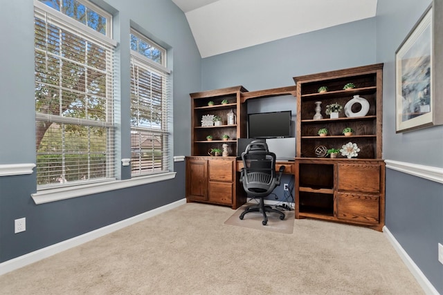 office area with baseboards, light colored carpet, and vaulted ceiling